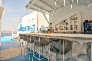 a bar with chairs and a bar counter at Astarte Suites in Akrotiri