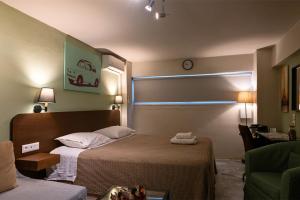 a bedroom with a bed and a window with a clock at Pol's studio, Kalamata Mediterranean Apartments in Kalamata