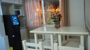 a white table with a vase of flowers and a window at Hostal Maribel in Almería