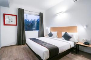 a bedroom with a large bed and a window at OYO Townhouse 588 Noida Sector 71 Near ISKCON Temple Noida in Indirapuram