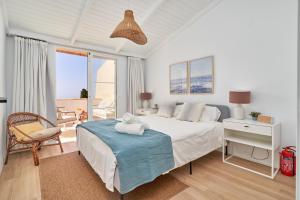a white bedroom with a bed and a large window at Apartamento Casita del Mar in La Herradura +19 photos
