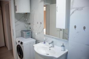 a bathroom with a sink and a washing machine at Holiday House Rose in Karlobag +48 photos