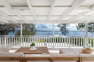 une véranda blanche avec un canapé et une table dans l'établissement The Cottage, à Bonnells Bay
