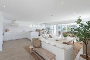 Il comprend un salon blanc avec un canapé blanc et une cuisine. dans l'établissement The Cottage, à Bonnells Bay