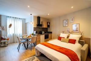 a bedroom with a bed and a table and a kitchen at Au Duplex d'Or Centre Historique in Besançon