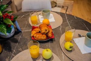 a table with a plate of pastries and orange juice at Au Duplex d'Or Centre Historique in Besançon
