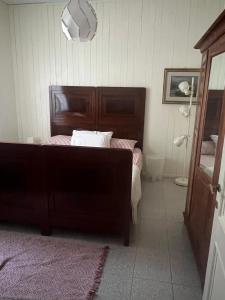 una camera da letto con un letto con testiera in legno di La casa dell’ edera a Lagune Altre 4 foto