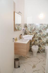 a bathroom with a sink and a toilet at La Loggia Suite in Marsala +47 photos