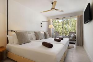 a bedroom with a large white bed and a living room at Inmood Aucanada 4 Sup in Port d'Alcudia