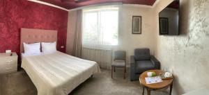 a bedroom with a bed and a table and a chair at Hotel MARUNA in Sevan