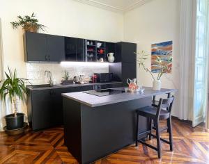 a kitchen with a black island in a room at Emozione Torino - affascinante, silenzioso, in palazzo d'epoca pressi piazza Solferino in Turin