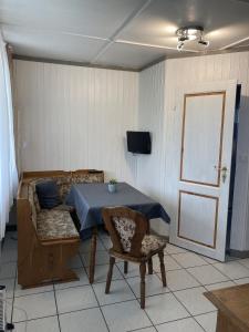 Habitación con mesa, sofá y TV. en Bunte Ferienhaussiedlung, en Rheinsberg
