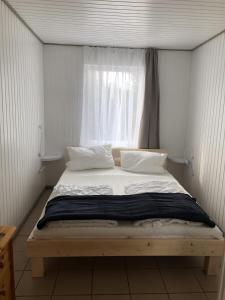 una cama en una habitación con ventana en Bunte Ferienhaussiedlung, en Rheinsberg