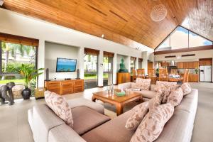 a living room with a couch and a table at Baan Grand Vista - Panoramic Sea View 5 Bed Pool Villa in Bophut