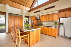 a kitchen with wooden cabinets and a large island at Baan Grand Vista - Panoramic Sea View 5 Bed Pool Villa in Bophut