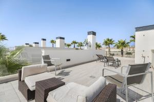 Un patio con sillas y muebles en la parte superior de un edificio. en Belle, en Playas de Orihuela