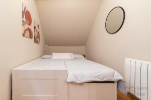 a small bedroom with a bed with a mirror at Fogar do Freixo - by entreRías in Cangas de Morrazo