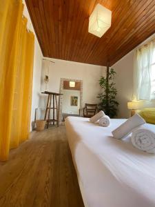 a bedroom with a large white bed with a wooden ceiling at Guesthouse Évasion in Contis-les-Bains +8 photos
