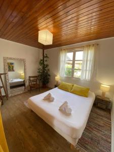 a bedroom with a large white bed and a mirror at Guesthouse Évasion in Contis-les-Bains