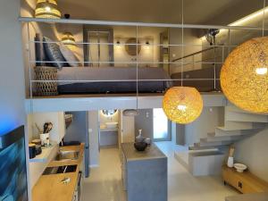 a room with a bed and a kitchen with a staircase at Bellaqua seaview loft suite in Neoi Epivates