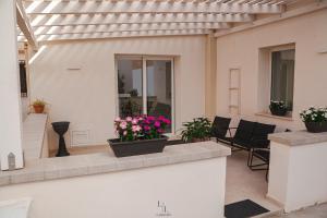 a patio with flowers in pots on a building at La Loggia Suite in Marsala