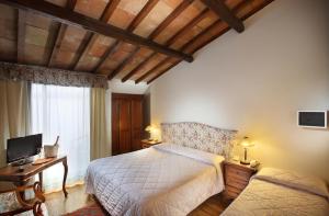 a bedroom with a bed and a couch and a television at Hotel Internazionale in Montecatini Terme +15 photos