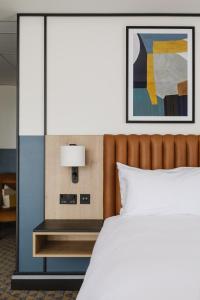 a bedroom with a bed and a table with a lamp at voco Belfast by IHG in Belfast