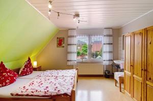 a bedroom with a bed with red pillows and a window at Ferienhaus Gerda Wohnung 2 in Westochtersum