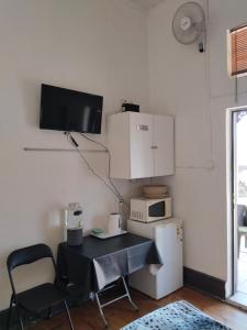 a room with a table and a microwave and a refrigerator at Reis n Rus in Harrismith +9 photos