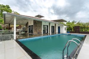 a swimming pool in front of a house at SaffronStays Le Soil, Igatpuri - pet-friendly villa with viewing deck for panoramic views in Igatpuri