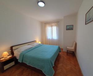 a bedroom with a bed and a table and a window at RIKY Ap4 - few steps from the beach in Novigrad Istria
