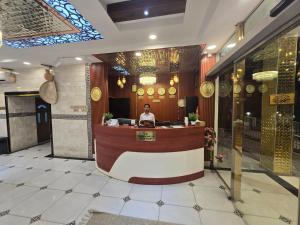 a man sitting at a counter in a restaurant at Dar Al Salaam Hospitality House in Nizwa