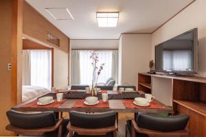 a living room with a table with chairs and a television at Daini Kuwamura Building 4th in Tokyo