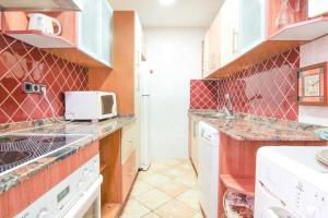 une cuisine avec un évier et un micro-ondes dans l'établissement Apartment with communal pool Muralla Roja 0505, à Calp