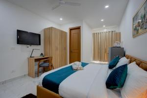 a bedroom with a large bed with blue pillows at The Lodgers Studio Apartment Near Mall FiftyOne Gurugram in Gurgaon