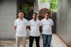 three men wearing white shirts standing in front of a house at VaNa - A Lindsay Manor in Vagator +37 photos