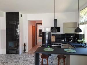 a kitchen with a black counter and two bar stools at agroturystyka Drużno in Elblag