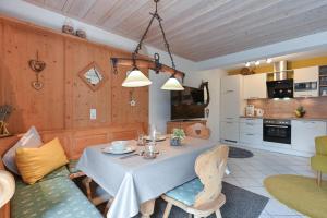 a dining room with a table and a kitchen at Ferienwohnung Alpina in Roßhaupten
