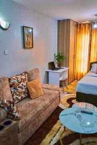ナイロビにあるONEAL URBAN SUITES - Furnished Studio apartments in Nairobiのソファ、ベッド、テーブルのあるリビングルーム +17枚の写真