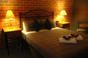 a bedroom with a bed and a lamp at Poachers Paradise in Rutherglen