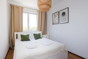 a bedroom with a white bed with green pillows at ShortStayPoland Tomcia Palucha B118 in Warsaw