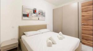 a bedroom with two beds with white sheets at Claremont 1bedroom apartment in Taʼ Xbiex