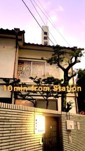 a building with a sign that reads bonion min from station at Guest House BONITO in Kochi