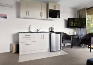 cocina con nevera de acero inoxidable y comedor en Bushview Retreat, en Paihia 3 fotos más