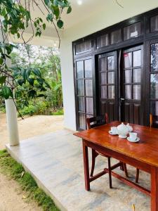 a wooden table and a bench in front of a house at Saveen View Ella in Ella