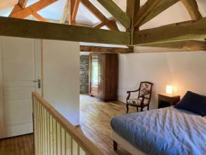 a bedroom with a bed and a chair in a room at Vakantiehuis La Poire, op landgoed aan de Dordogne in Prudhomat