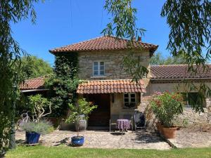 a small stone house with a table and chairs in a yard at Vakantiehuis La Poire, op landgoed aan de Dordogne in Prudhomat
