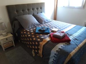 a bed with a blanket and two towels on it at Maison Chalet in Le Nayrac