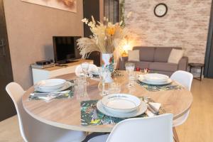 a dining room table with plates and glasses on it at Appartement Le Welcome in Argelès-Gazost +18 photos
