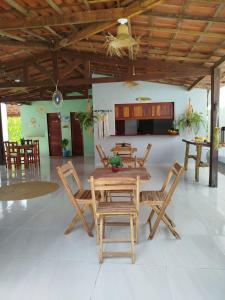 a dining room with a wooden table and chairs at Côco Verde - Pousada Icaraí Kite Village in Icaraí